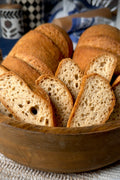 Sliced Gluten Free bread in a wooden bowl with a blurred background