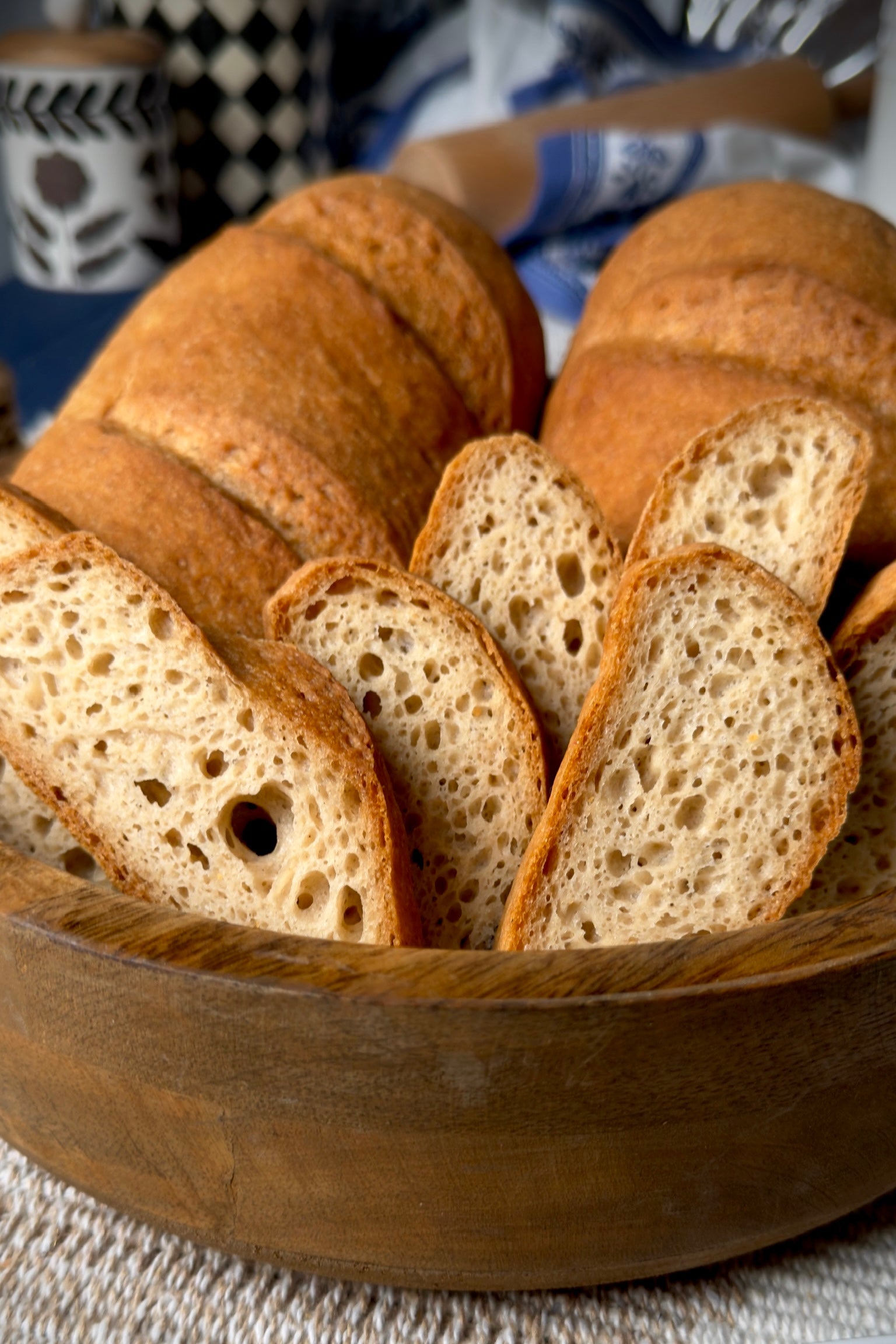 Sliced Gluten Free bread in a wooden bowl with a blurred background